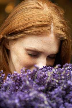 a photo of a woman smelling lavendar